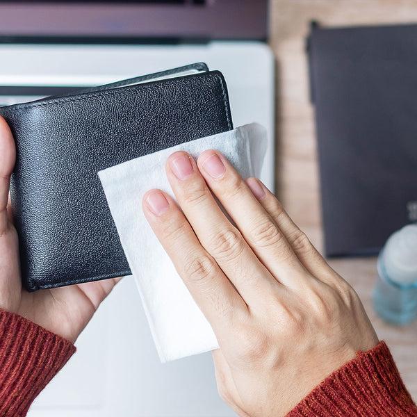 Portefeuille en cuir noir nettoyé avec un chiffon doux pour préserver son entretien et sa qualité