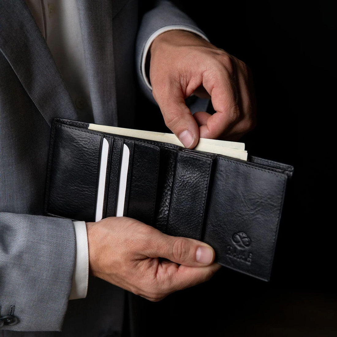 Homme vérifiant ses cartes dans un portefeuille en cuir avant un déplacement