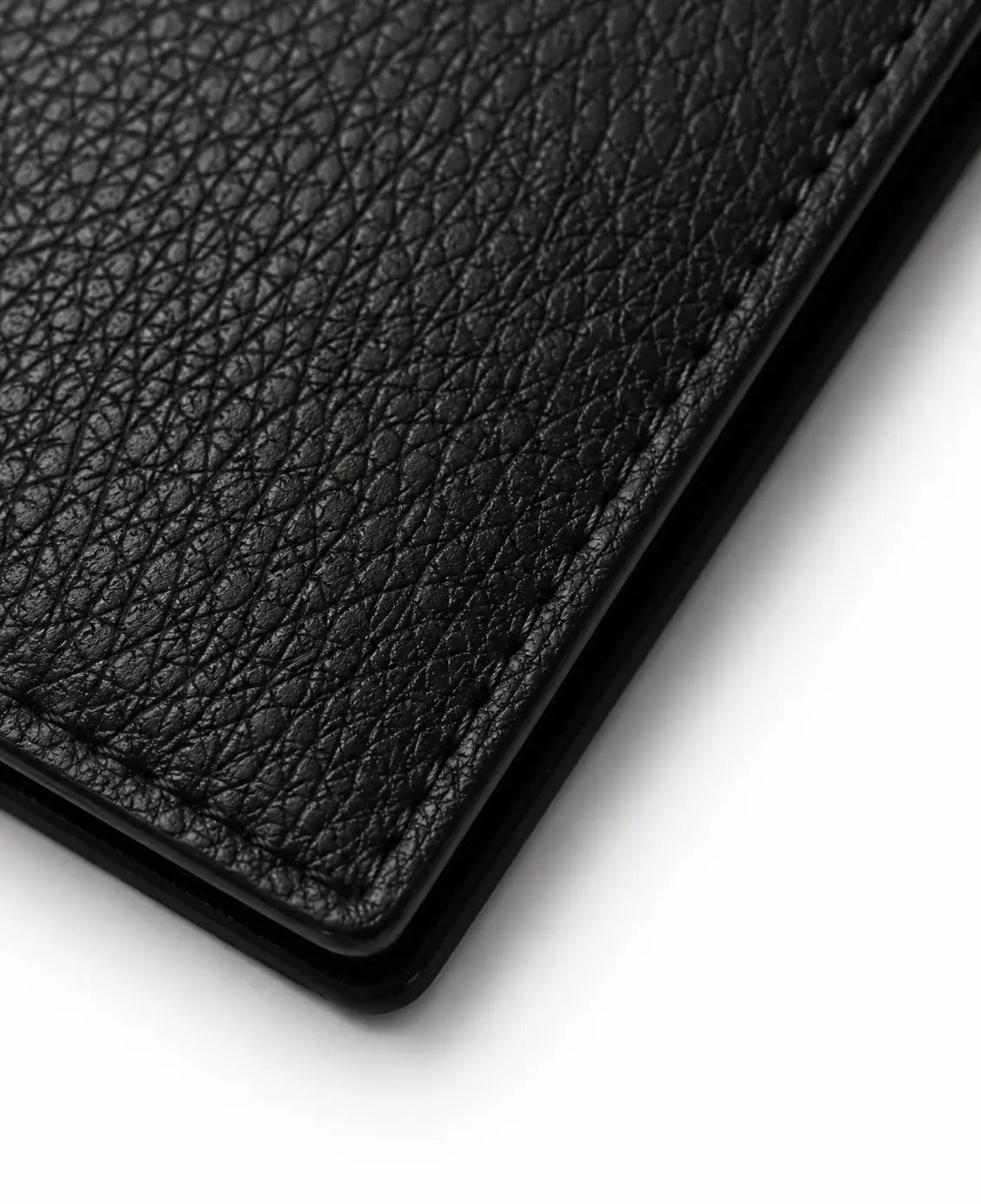 Gros plan sur le cuir véritable du portefeuille cuir homme noir révélant la texture et la qualité de finition