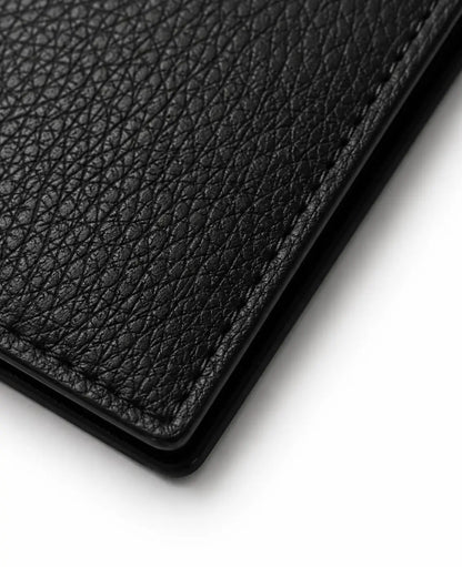 Gros plan sur le cuir véritable du portefeuille cuir homme noir révélant la texture et la qualité de finition